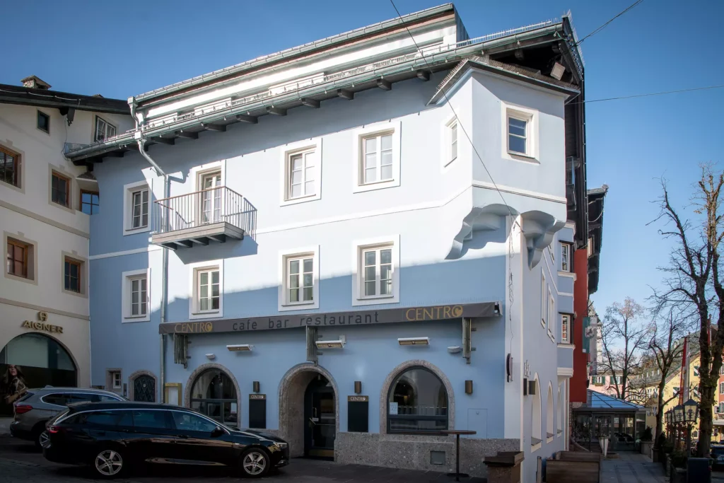 H2S - Die Errichtung von Wohnungen in drei Obergeschossen sowie die Neugestaltung der Fassade erfolgte in Abstimmung mit der Stadt Kitzbühel. Die generellen Umbauarbeiten des Altbestandes unter Berücksichtigung der bestehenden Einheiten im Erdgeschoss (Restaurant) und im 2. Obergeschoss (bestehendes Büro) stellten sich als eine besondere Schwierigkeit des Projektes dar. Die speziellen Herausforderungen waren die beengten Platzverhältnisse im Kerngebiet von Kitzbühel sowie die komplette Sanierung und teilweise Neuherstellung des Dachstuhles inklusiver damit verbundener statischer Neukonzipierung dieses Geschosses.
